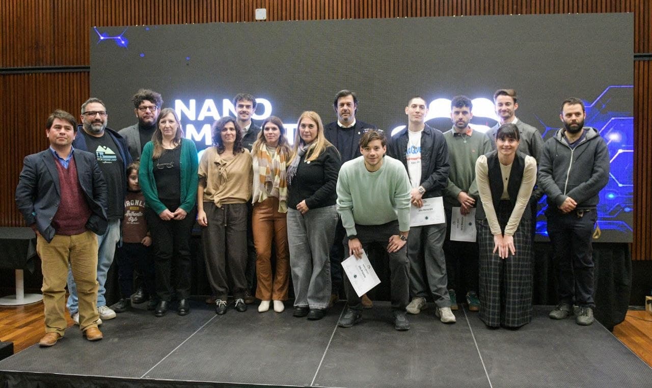 Foto grupal de los participantes de NANO IMPACT 2026 en el Centro Cultural de la Ciencia (C3), frente a la pantalla del evento